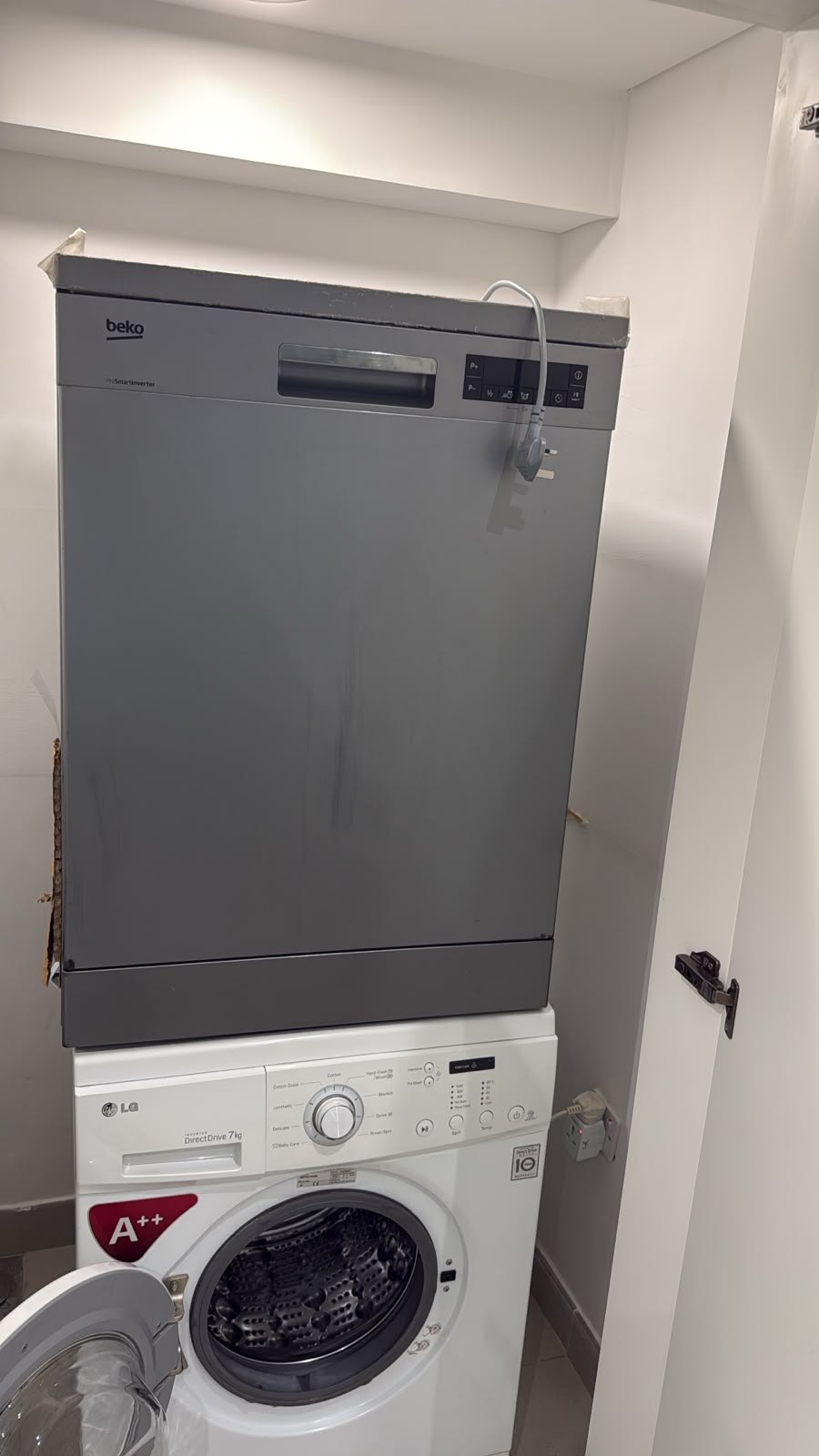 Freestanding dishwasher installed in a utility cupboard in a UAE home