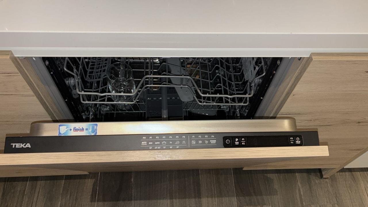 Integrated dishwasher with its door open and control strip showing on a UAE service call